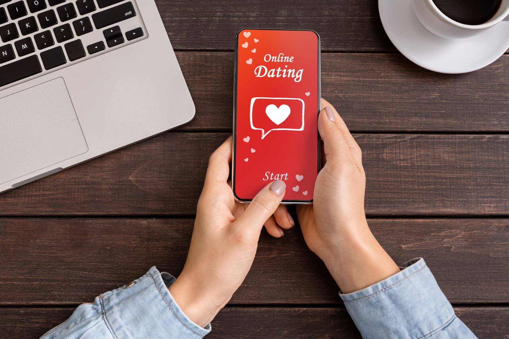 Picture of female hands holding smart phone and the screen is red and reads "online dating."