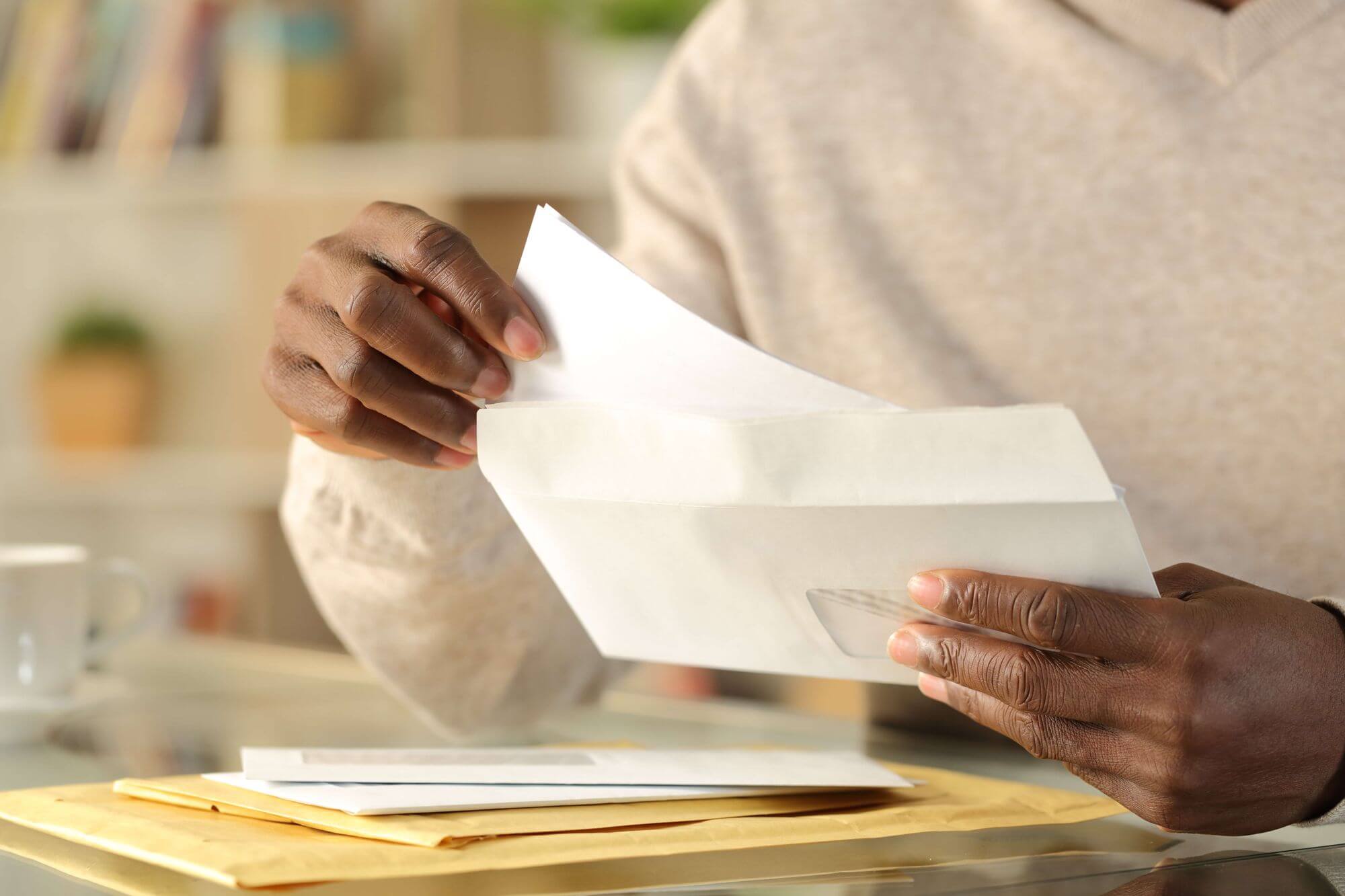 Close up photo of man with envelope in his hands. (Formal letter how to write, tips for writing a letter)